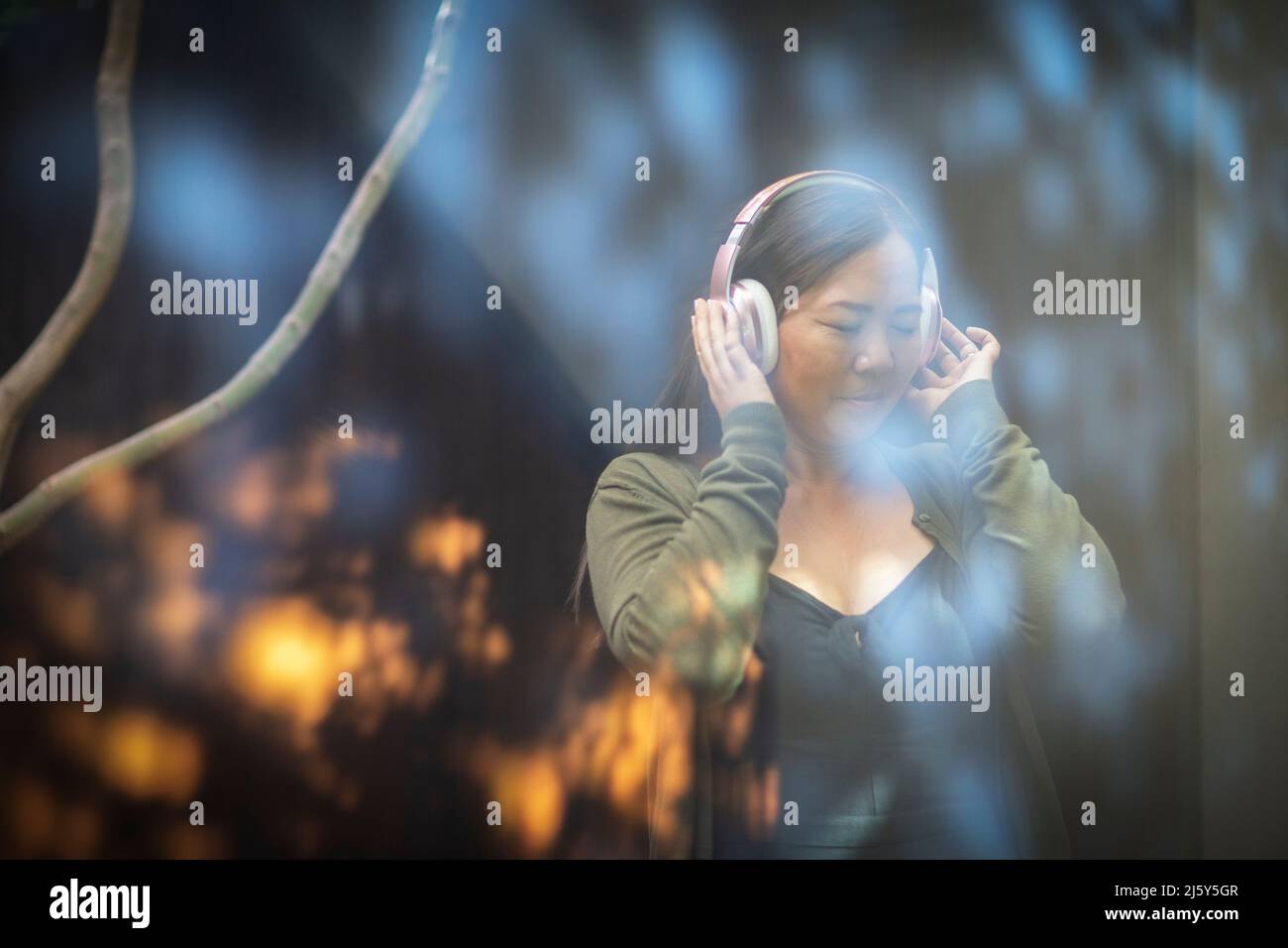 Femme sereine écoutant de la musique avec un casque Banque D'Images