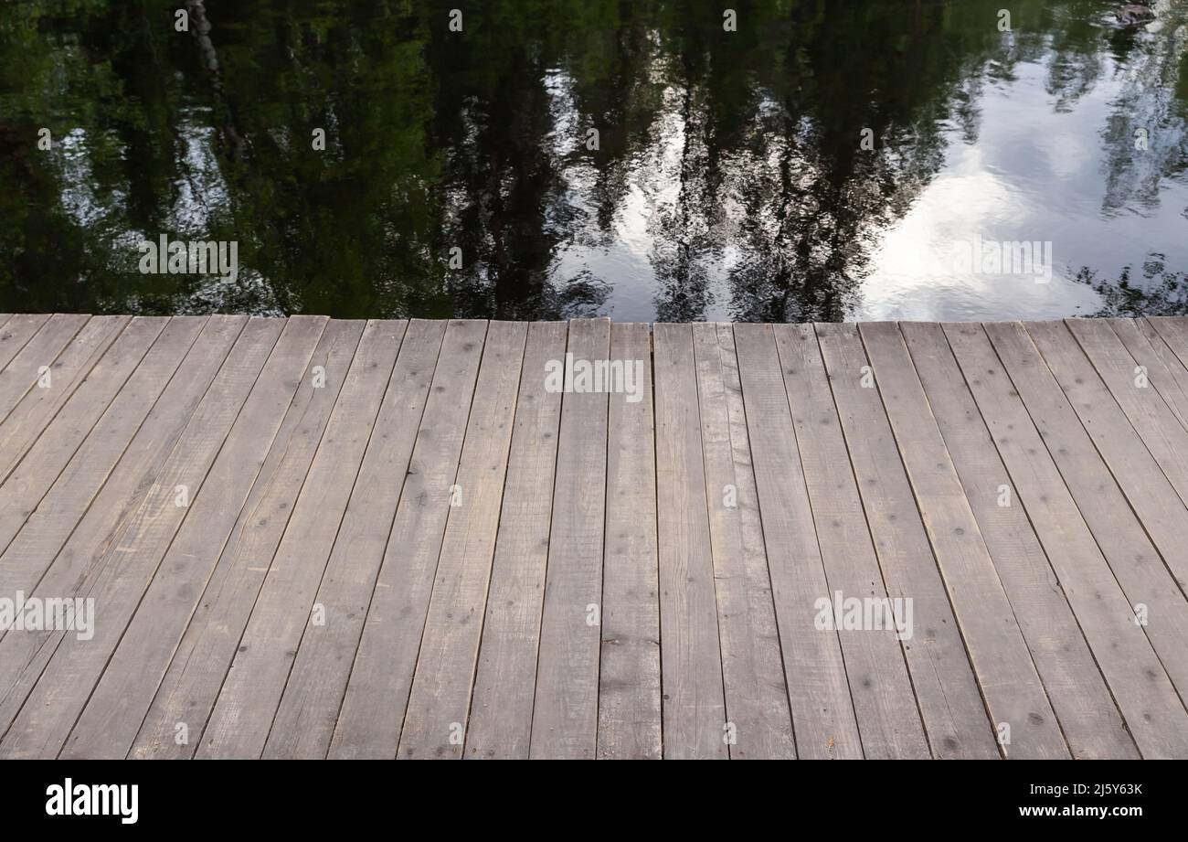 Ancienne jetée en bois et eau du lac avec des reflets, photo de fond abstraite Banque D'Images