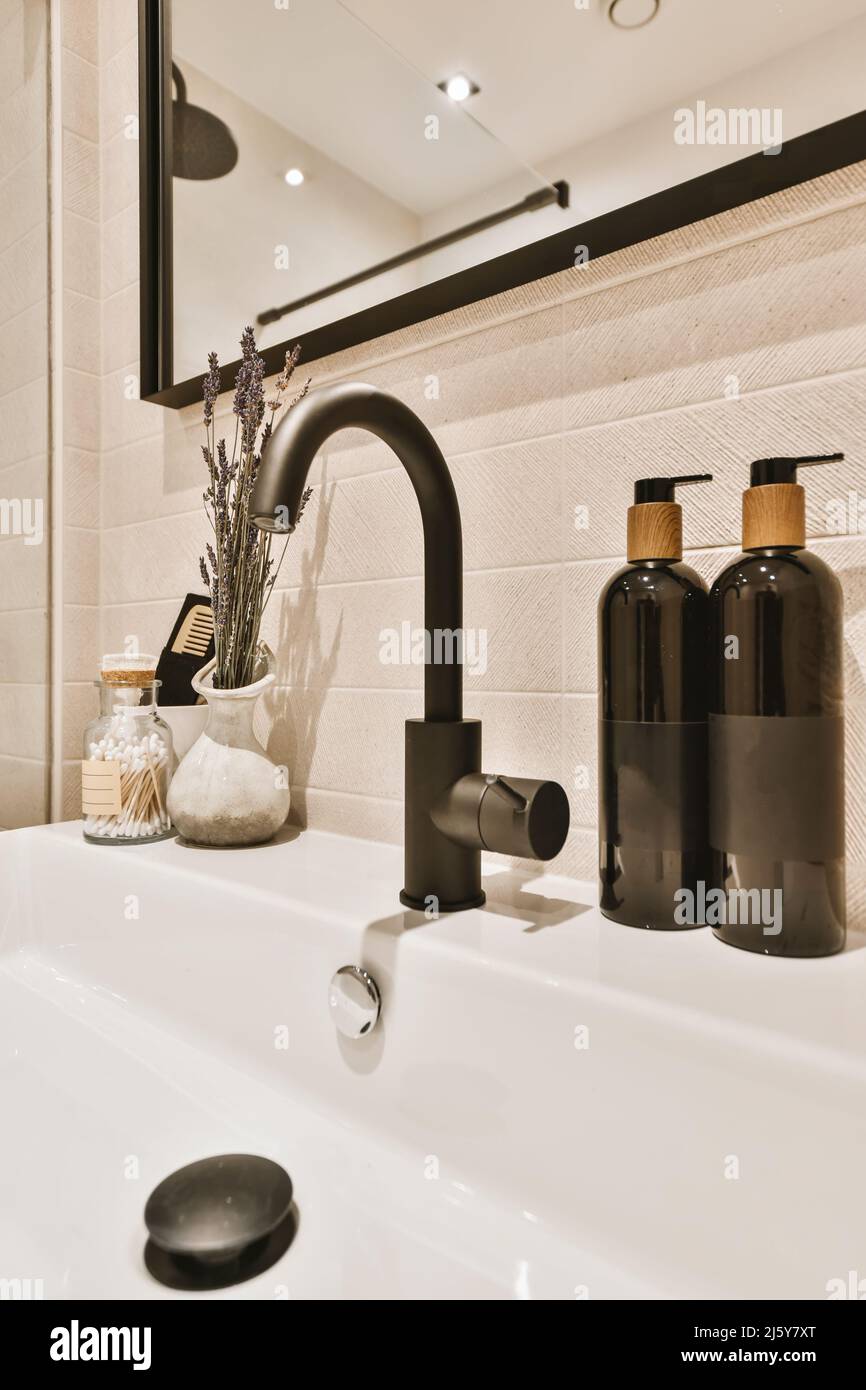 Gros plan d'un lavabo avec robinet noir, miroir et divers éléments  décoratifs sur le lavage Photo Stock - Alamy