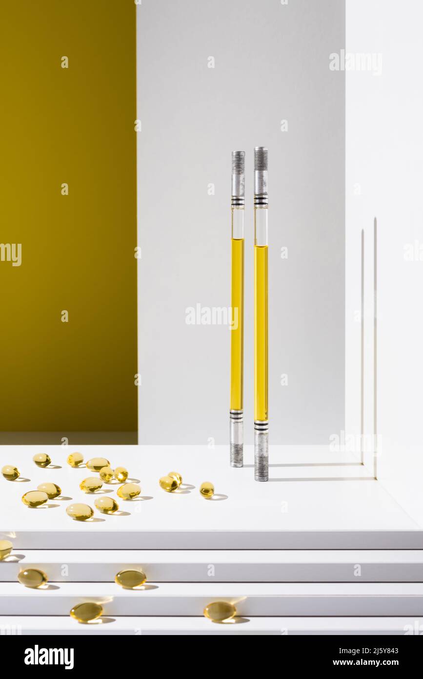 Récipients en verre contenant de l'huile pour la production de produits de soins de la peau et capsules d'oméga comme vitamines pour la santé dispersés dans un studio élégant Banque D'Images