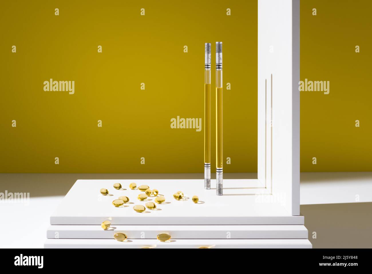 Récipients en verre contenant de l'huile pour la production de produits de soins de la peau et capsules d'oméga comme vitamines pour la santé dispersés dans un studio élégant Banque D'Images