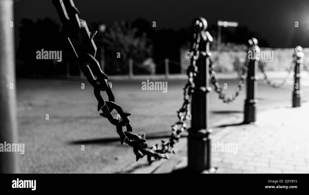 Image en noir et blanc de la clôture en chaîne à pointes à l'intersection Banque D'Images