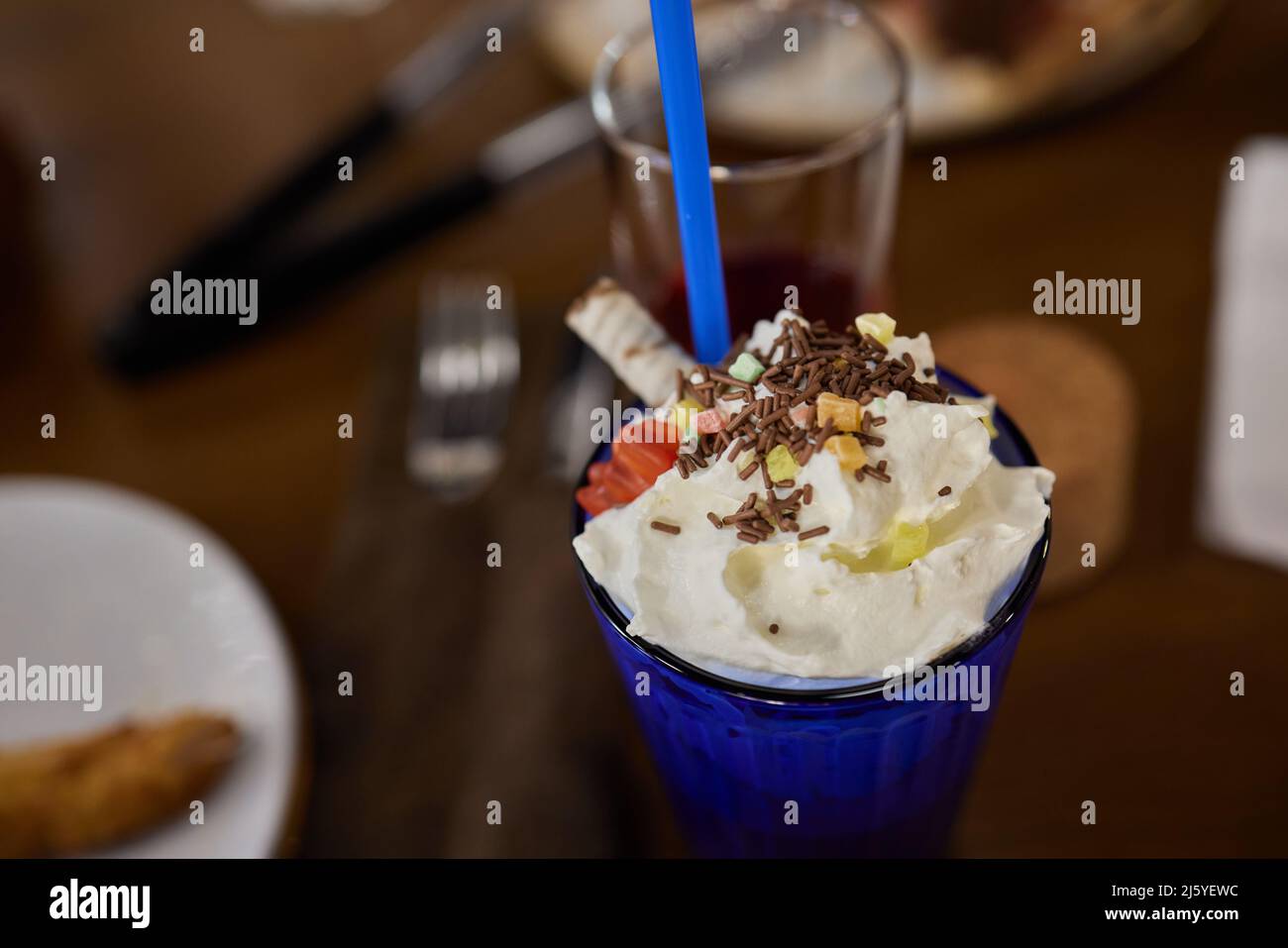 Délicieux milkshake glaçant au chocolat avec beignets et bonbons. Tendance à la fréakshake. Copier l'espace Banque D'Images