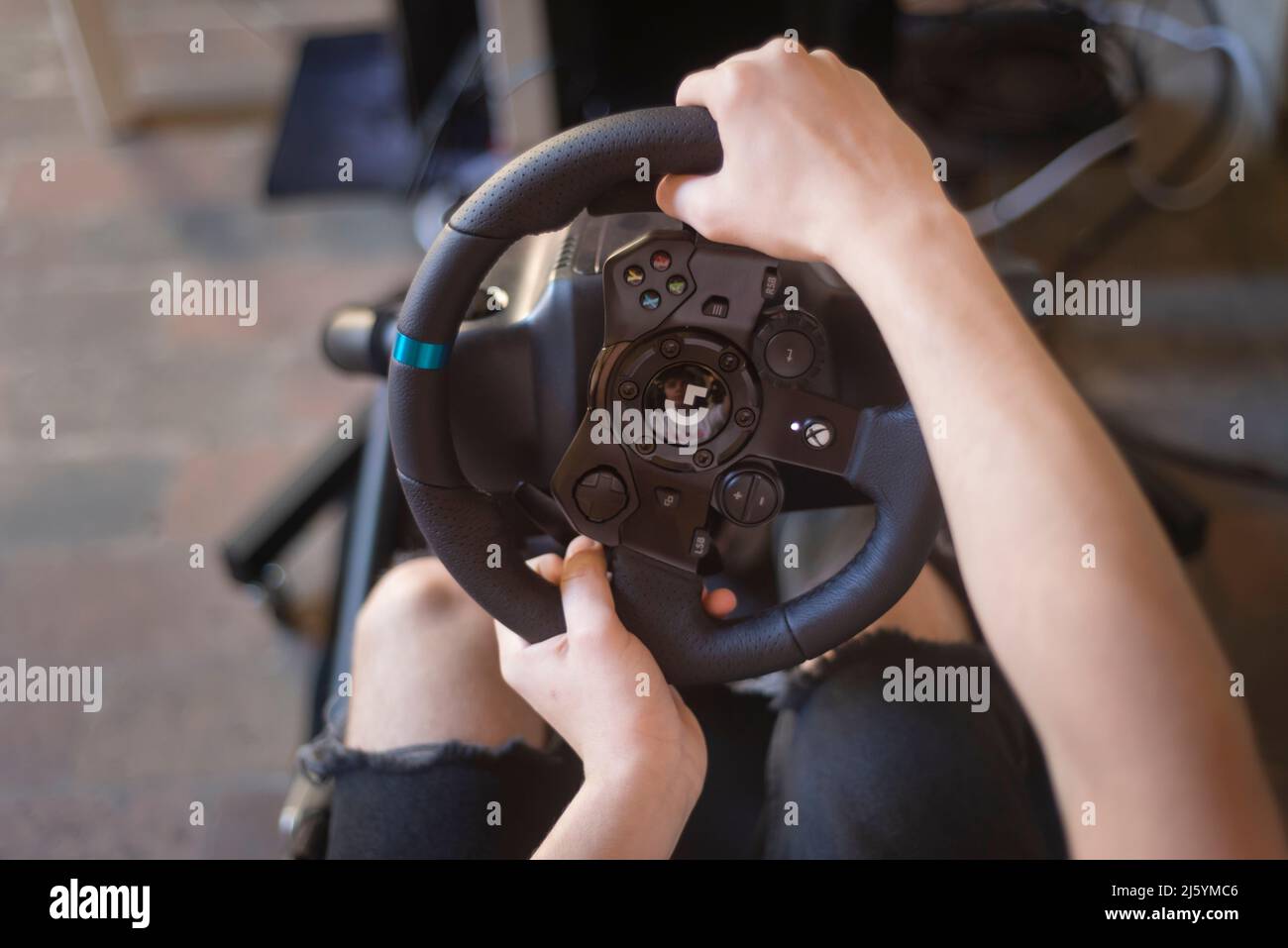 Mains d'un Teeneger sur un volant, pendant qu'il joue un jeu de course Banque D'Images