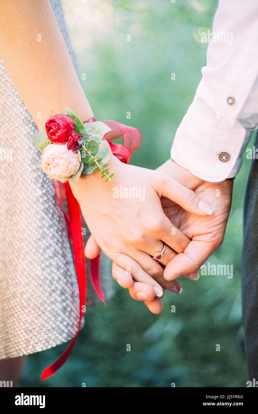 Inspiration de mariage Marsala. Mariée et marié tenant les mains sur fond vert, gros plan. Concept de mariage. Banque D'Images