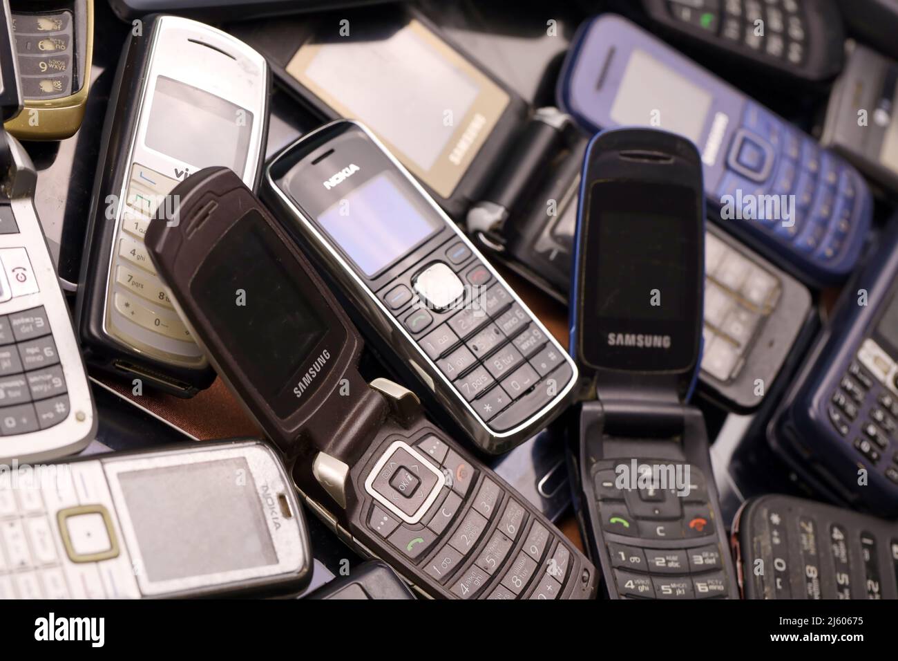 KHARKIV, UKRAINE - 16 DÉCEMBRE 2021 : certains vieux téléphones mobiles obsolètes utilisés de 90s-2000s période. Recyclage de l'électronique sur le marché bon marché Banque D'Images