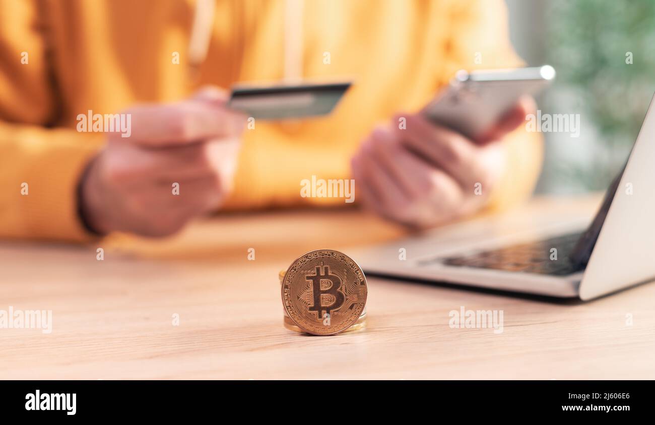 Bitcoin trading, homme utilisant un smartphone, ordinateur portable et carte de crédit pour acheter et vendre crypto-monnaie, foyer sélectif Banque D'Images