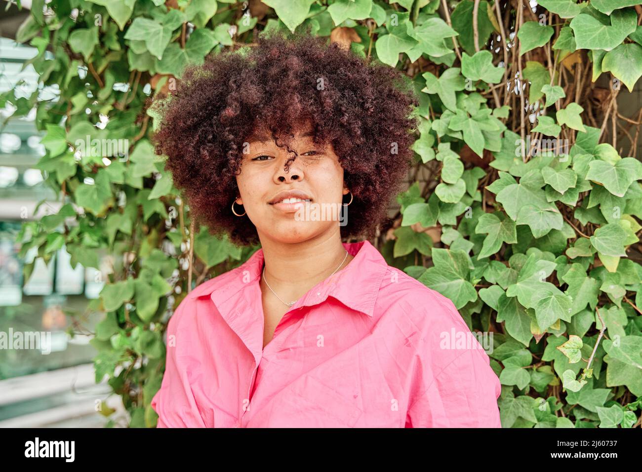 Portrait d'une femme afro-américaine regardant dans l'appareil photo avec des cheveux courbés et un corps curvy. Banque D'Images