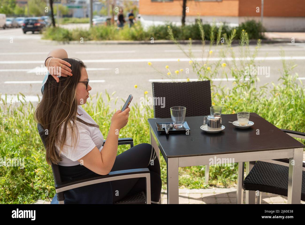 Cheveux longs latina jeune femme se reposant sur la terrasse d'été café-restaurant Banque D'Images