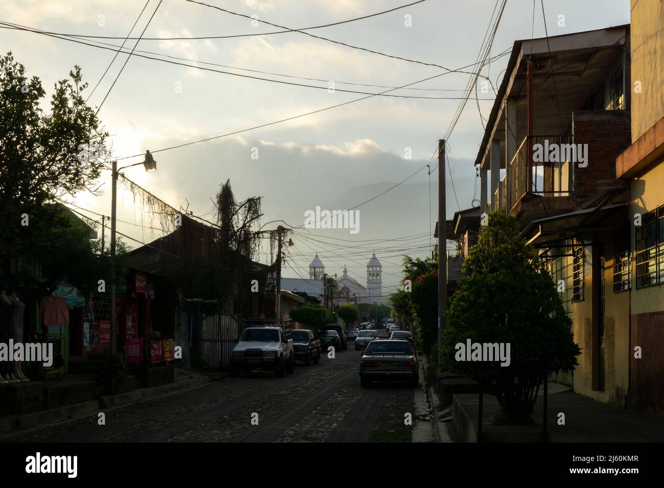 Juayua, El Salvador - 29 janvier 2022: Vue de la route vide avec des voitures garées dans la zone résidentielle de Juayua, El Salvador au coucher du soleil Banque D'Images