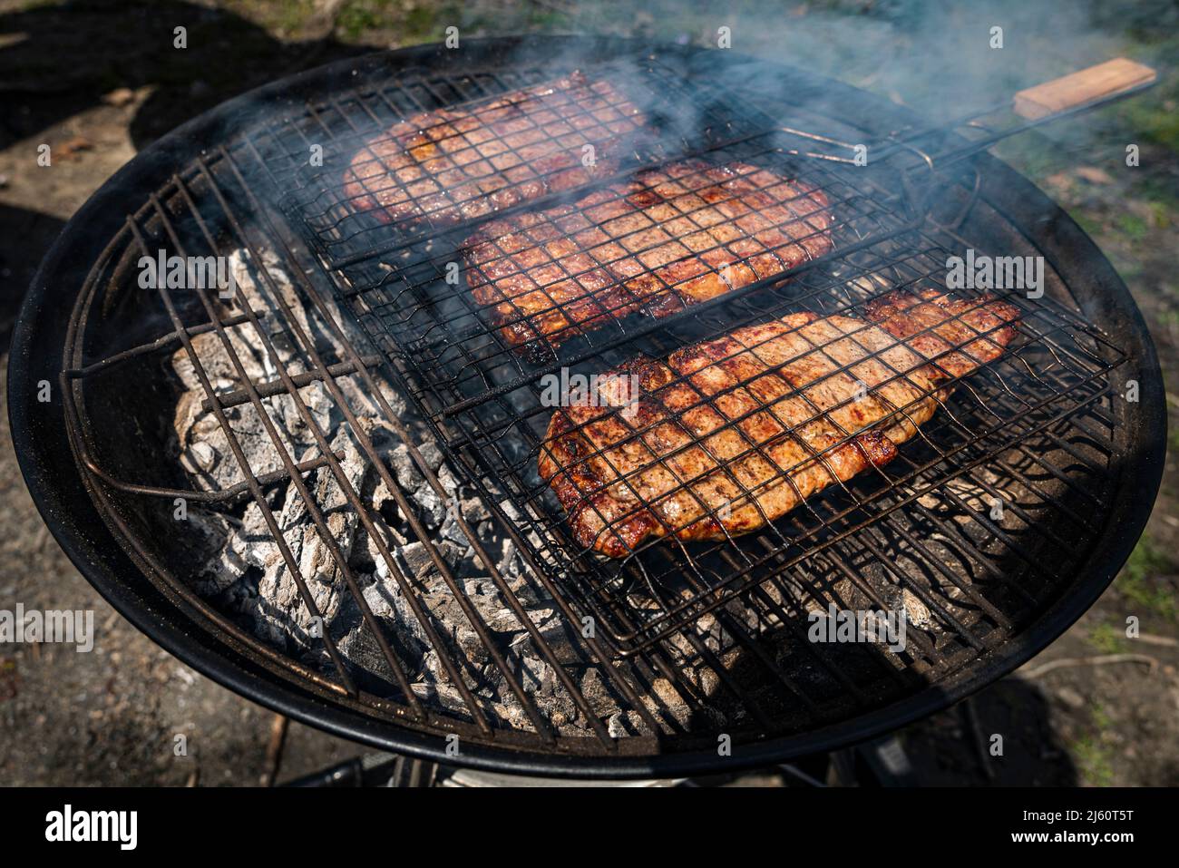 Mise au point sélective de steaks de bœuf juteux grillés sur grille barbecue avec fumée Banque D'Images