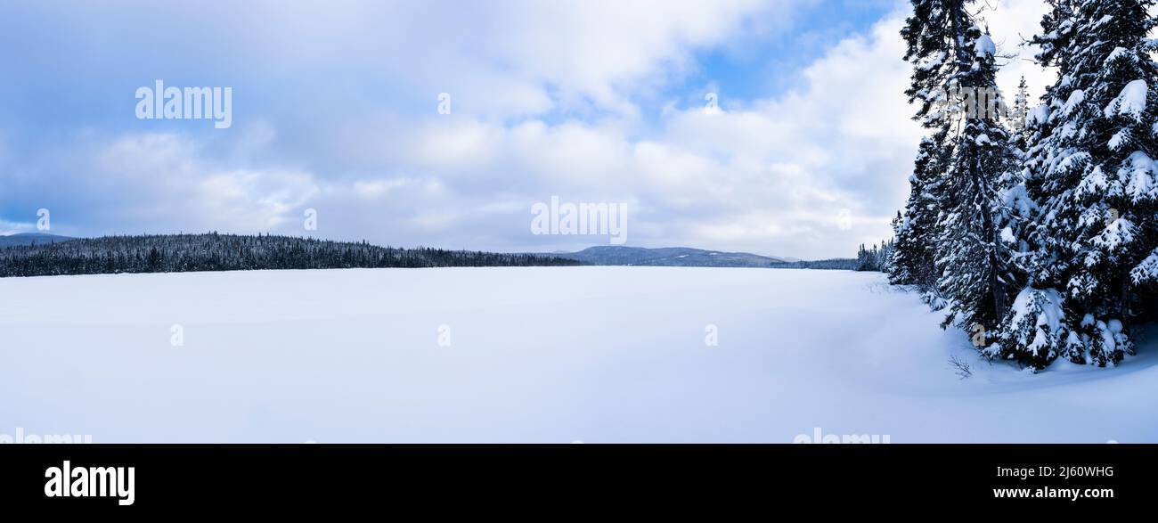 Vue panoramique d'un magnifique lac gelé et d'un ciel nuageux dans un parc national du Canada. Banque D'Images