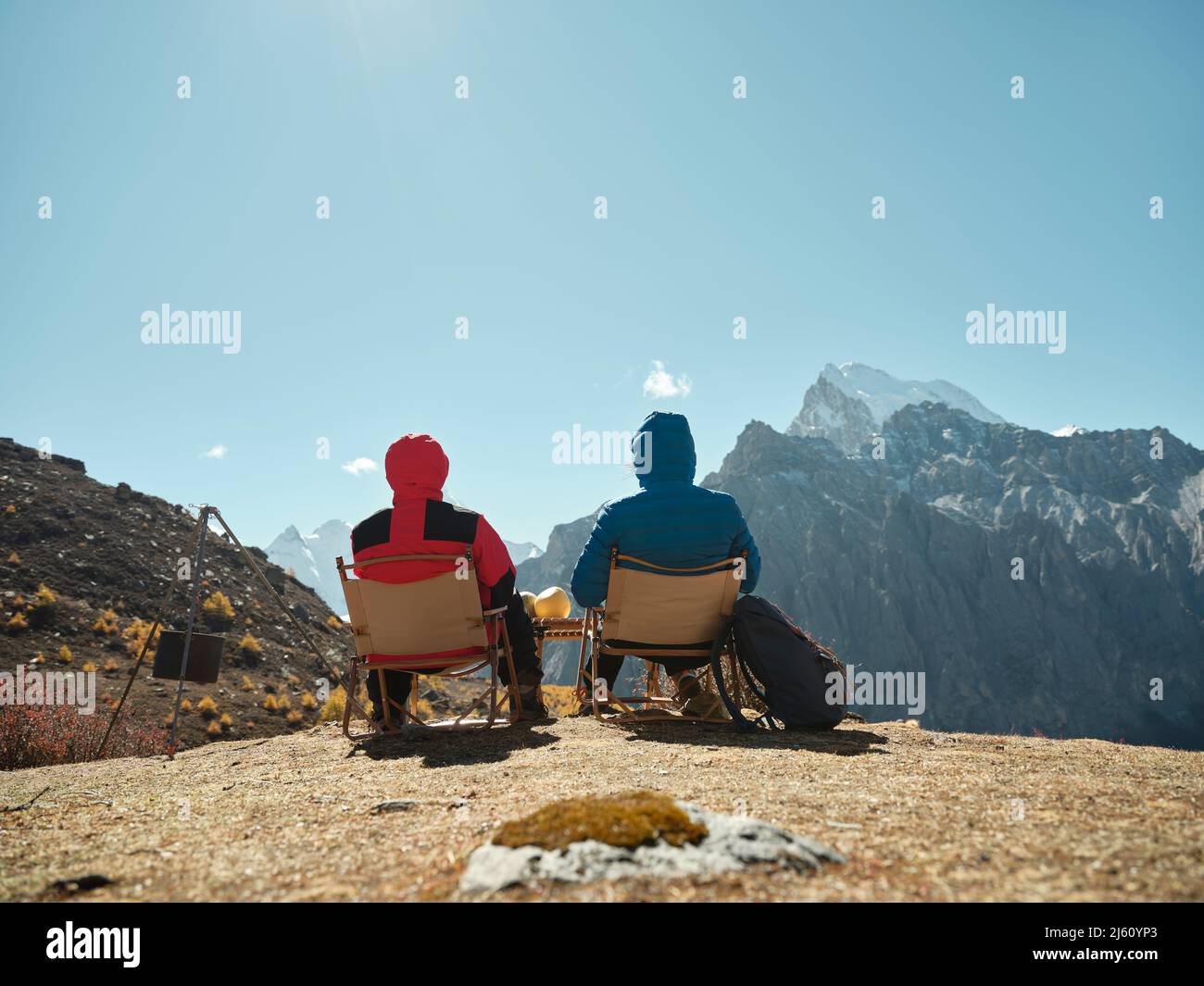 vue arrière d'un couple asiatique assis dans des chaises au sommet de la montagne, vue sur le parc national de yading, comté de daocheng, province du sichuan, chine Banque D'Images