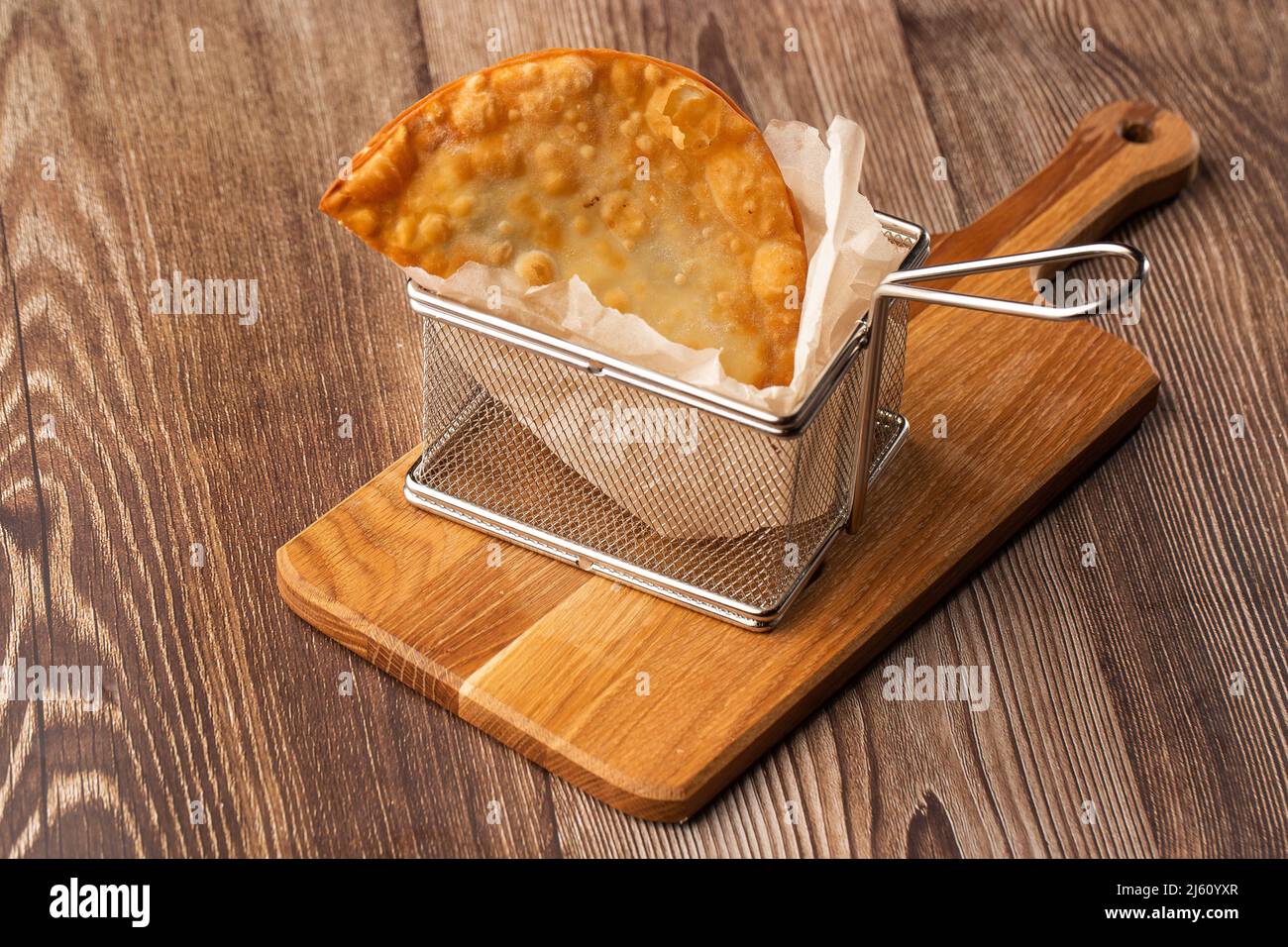 Cuisine ouzbek orientale tatar, chebureau sur une planche de bois. Chebureau - tarte frite à la viande. Plat traditionnel de turc et mongol, pasties empanada Banque D'Images
