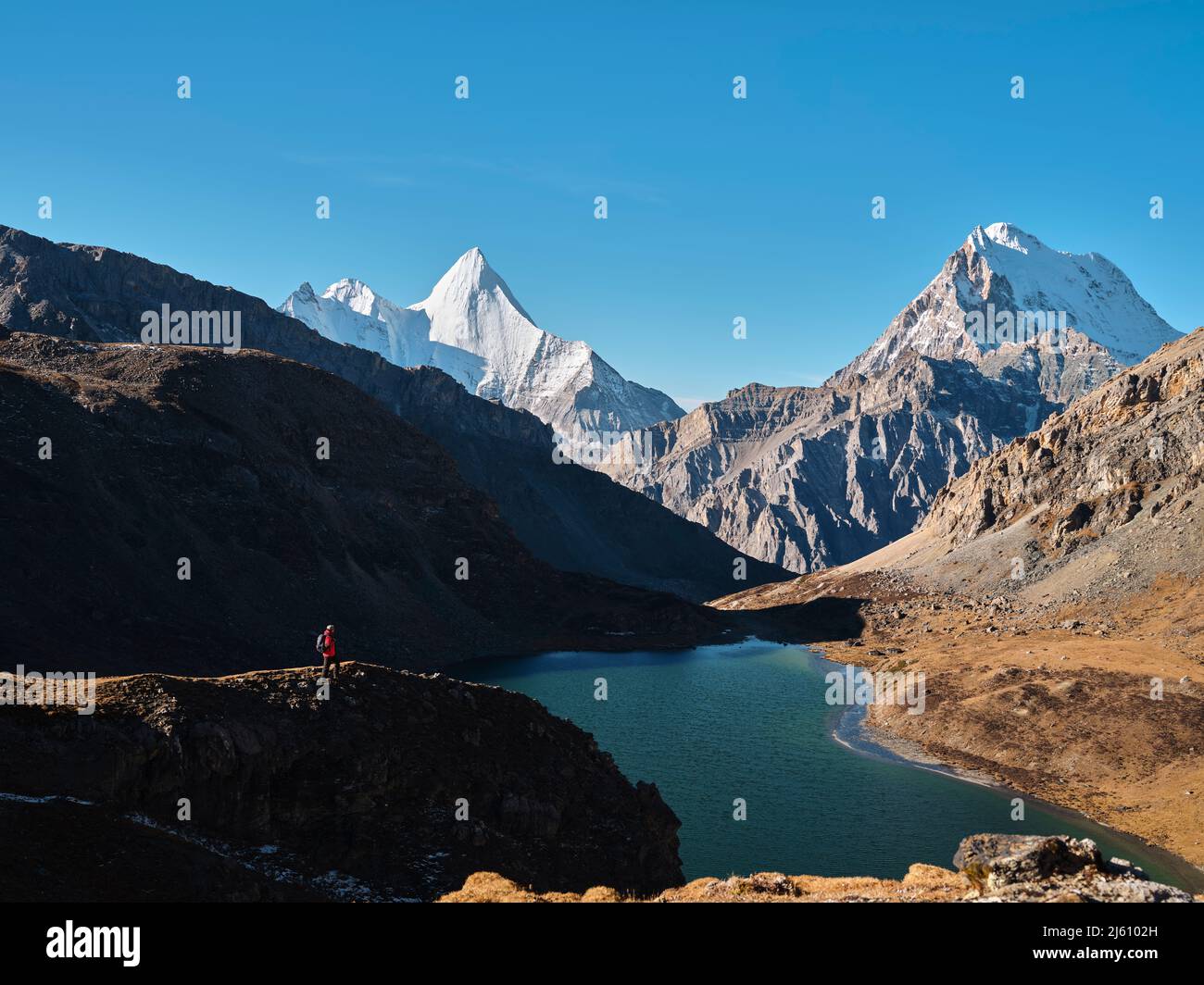 randonneur asiatique regardant le mont jampayang, le mont chanadorje et le lac boyongcuo au lever du soleil dans le parc national de yading, comté de daocheng, province de sichuan, chi Banque D'Images