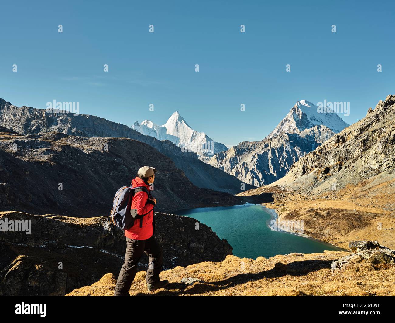 randonneur asiatique regardant le mont jampayang, le mont chanadorje et le lac boyongcuo au lever du soleil dans le parc national de yading, comté de daocheng, province de sichuan, chi Banque D'Images