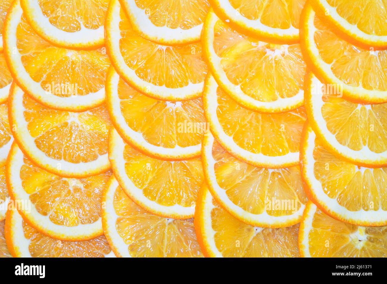 Tranches de citron orange sur fond jaune. Une coupe orange en tranches est située sur la table. Banque D'Images