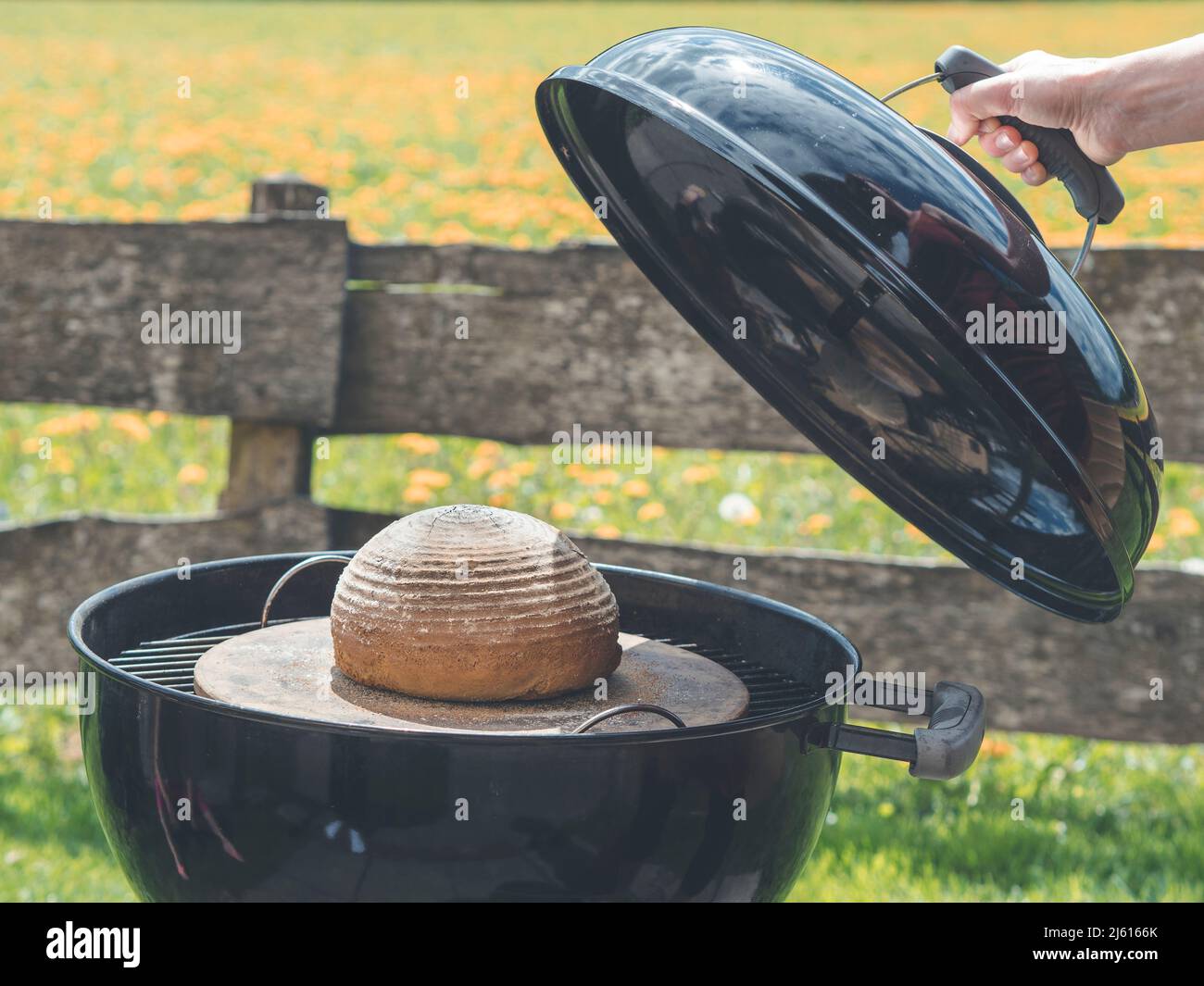 comment faire cuire du pain dans le jardin en utilisant un barbecue au  charbon de bois dans le jardin avec belle clôture de jardin à  l'arrière-plan Photo Stock - Alamy