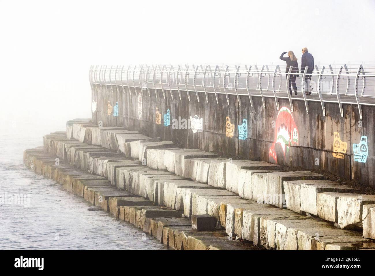 Couple marchant un matin brumeux au brise-lames d'Ogden point - Victoria, île de Vancouver, Colombie-Britannique, Canada Banque D'Images