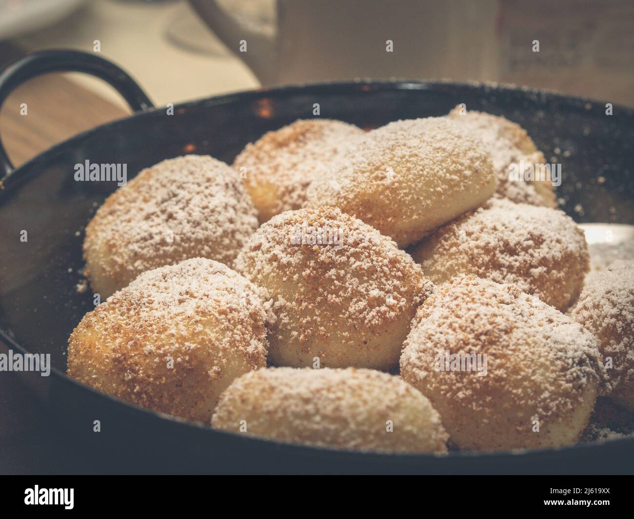 L'image montre un groupe de boulettes d'abricot - Marillenknödel servi dans une casserole rustique et garni de chapelure et de sucre en poudre Banque D'Images