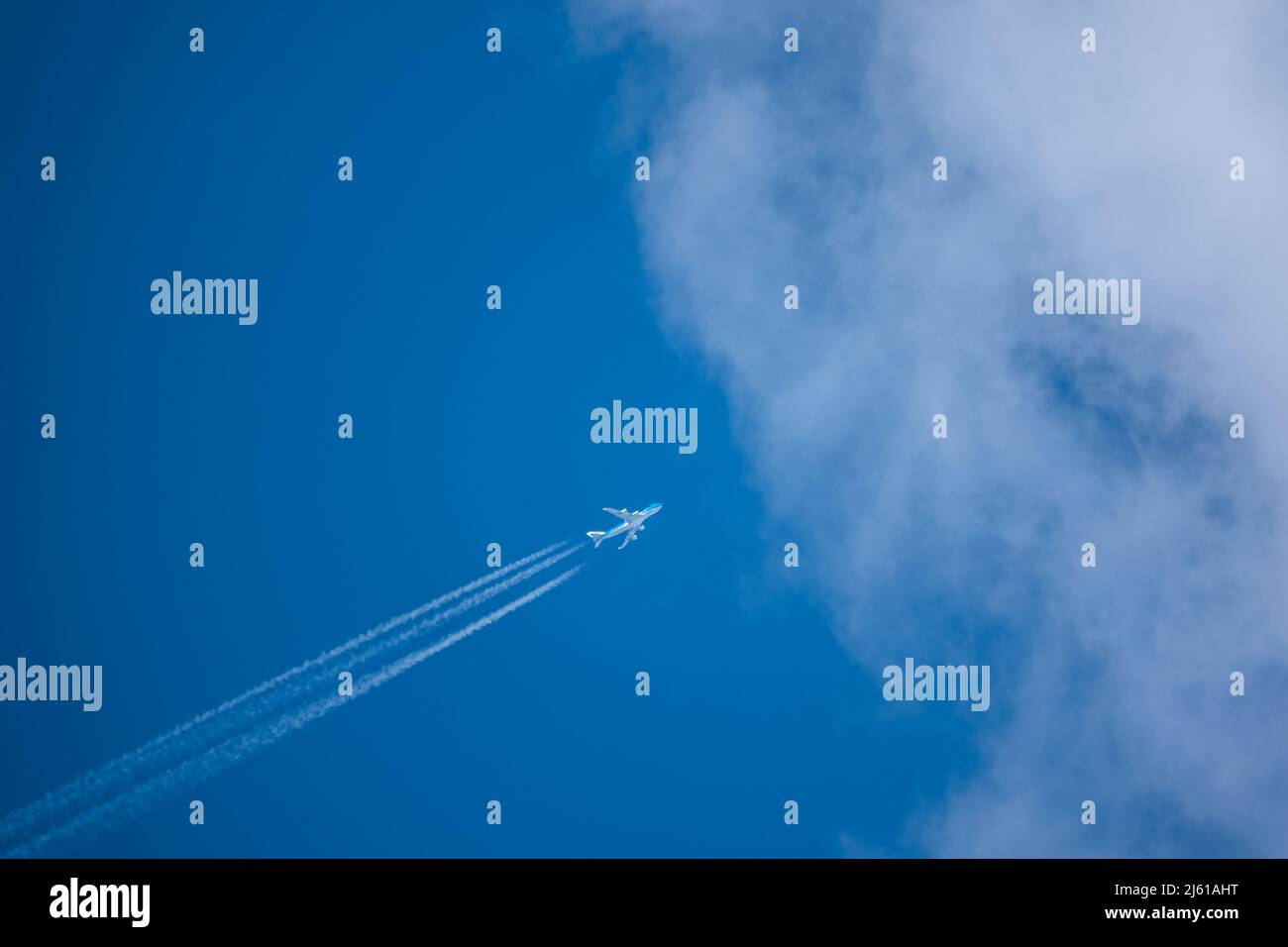 Diagonale inférieure gauche à supérieure droite haute altitude contrentre un Boeing 747-400 à quatre moteurs à jet géant cargo KLM entrant dans le ciel bleu nuage Banque D'Images