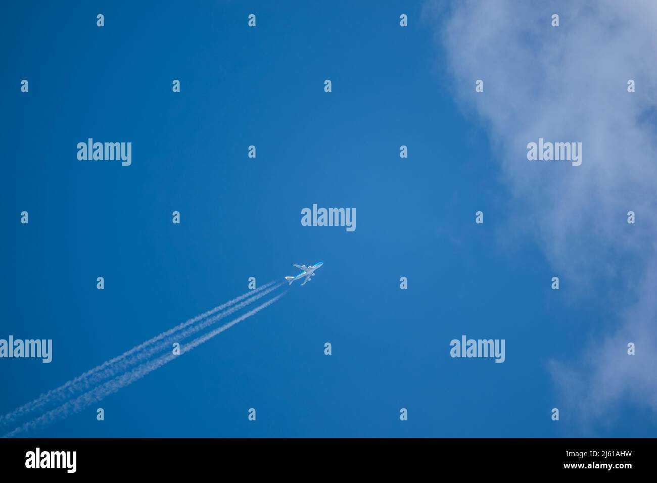 Diagonale inférieure gauche à supérieure droite haute altitude contrentre un Boeing 747-400 à quatre moteurs à jet géant cargo KLM entrant dans le ciel bleu nuage Banque D'Images