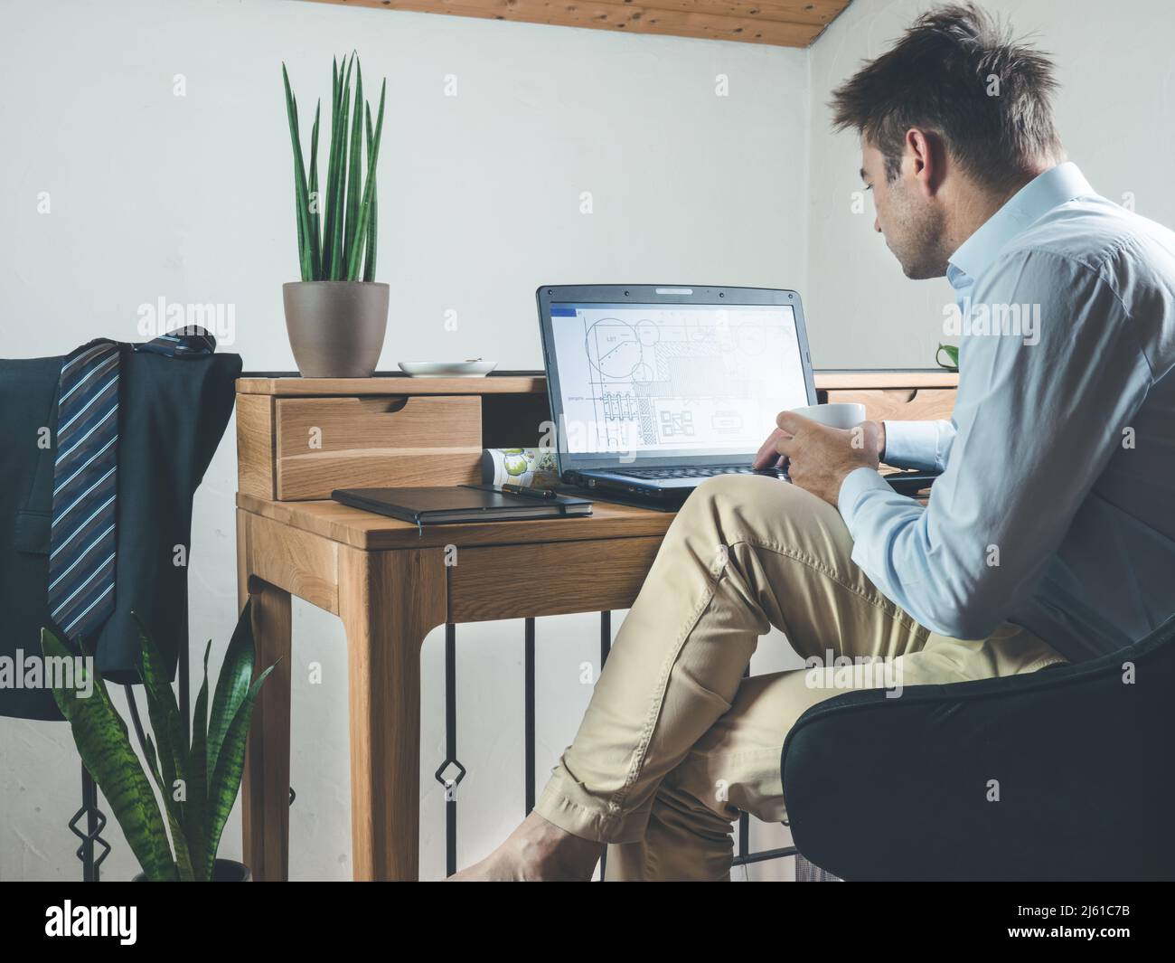 l'image montre un bureau à domicile avec un architecte travaillant sur un bureau conçu sur un ordinateur portable Banque D'Images