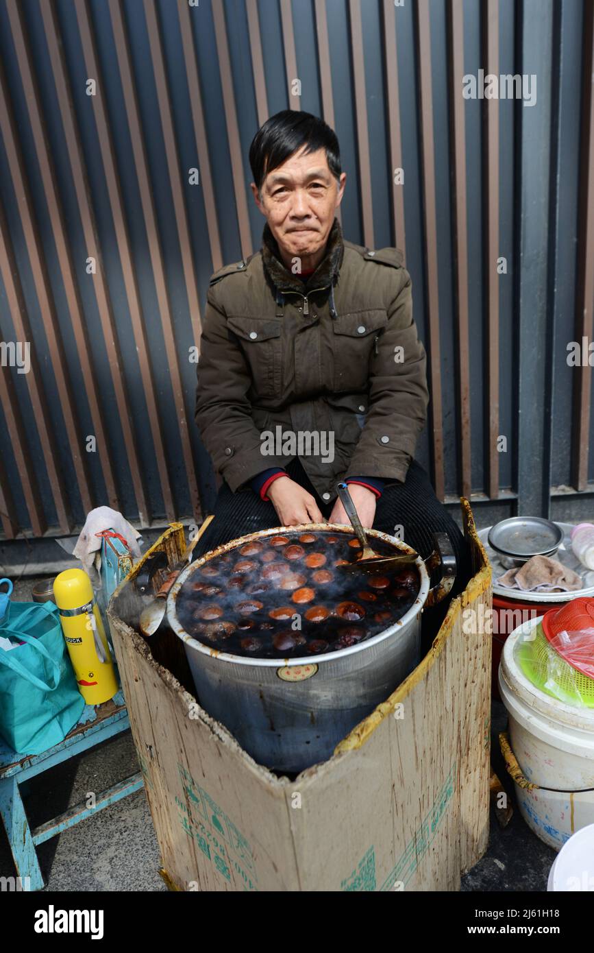 Une femme locale cuisant des œufs traditionnels de feuilles de thé. Les œufs sont cuits dans le thé, la sauce soja et d'autres épices et sont un commun dans toute la Chine. Banque D'Images