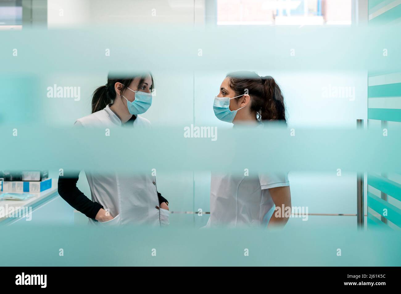 Les infirmières dans les masques protecteurs du visage discutant à la clinique maxillofacial Banque D'Images