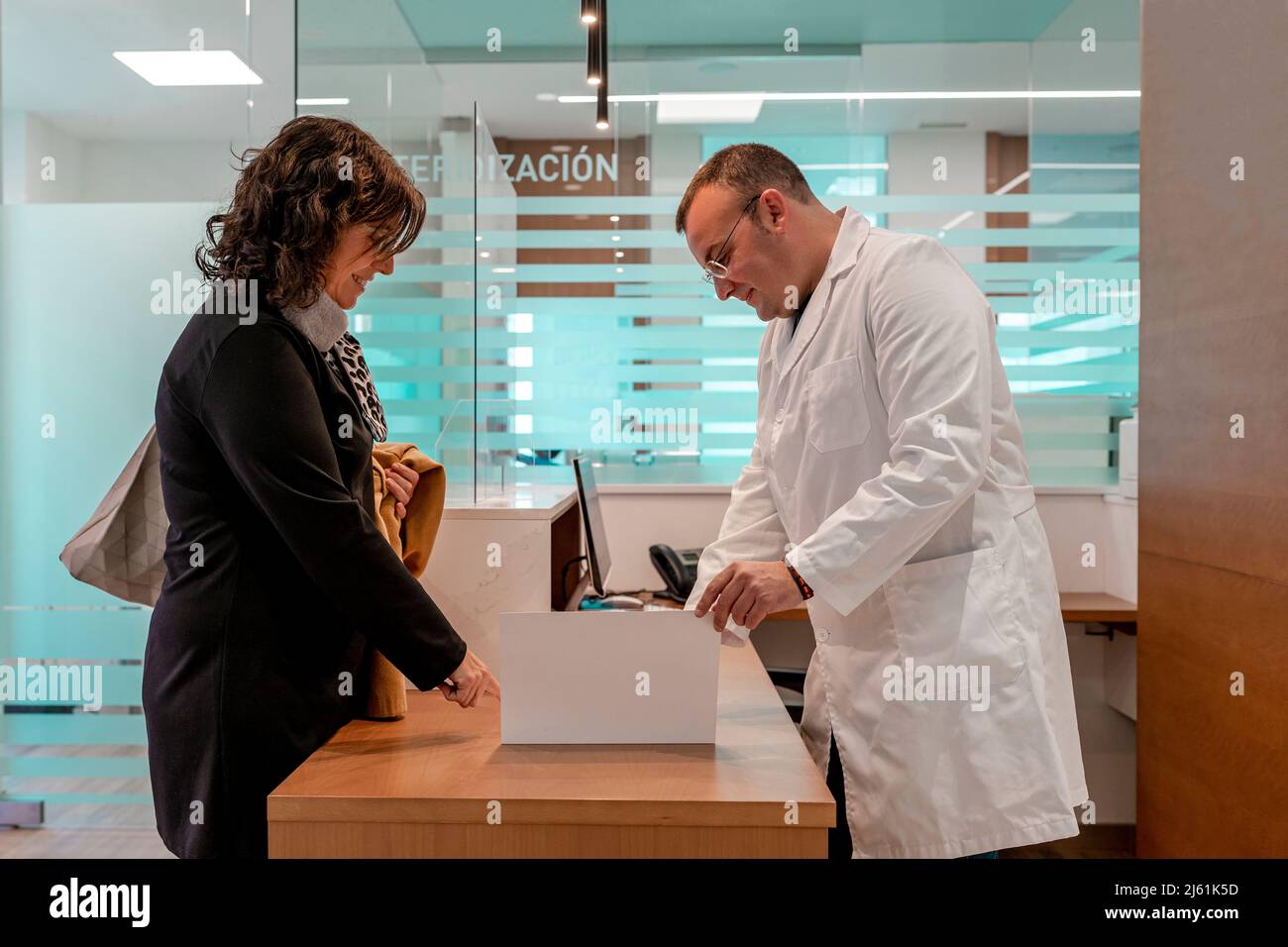Médecin présentant un rapport médical au patient à la réception à l'hôpital Banque D'Images