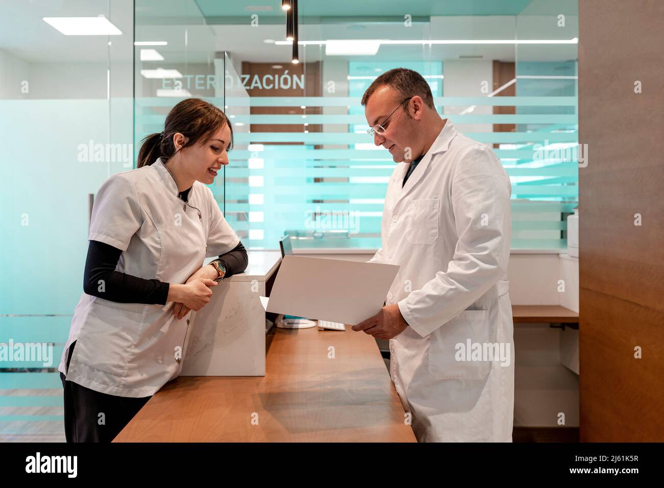 Médecin et infirmière discutant du dossier médical à la réception de l'hôpital Banque D'Images