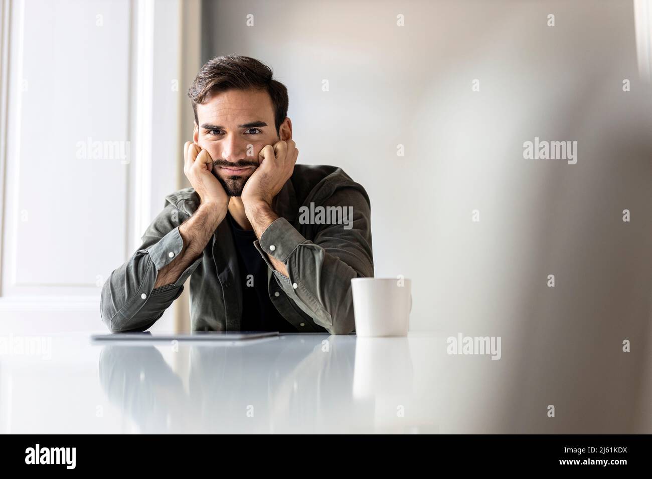 Énervé homme avec un Tablet PC assis sur une table à la maison Banque D'Images