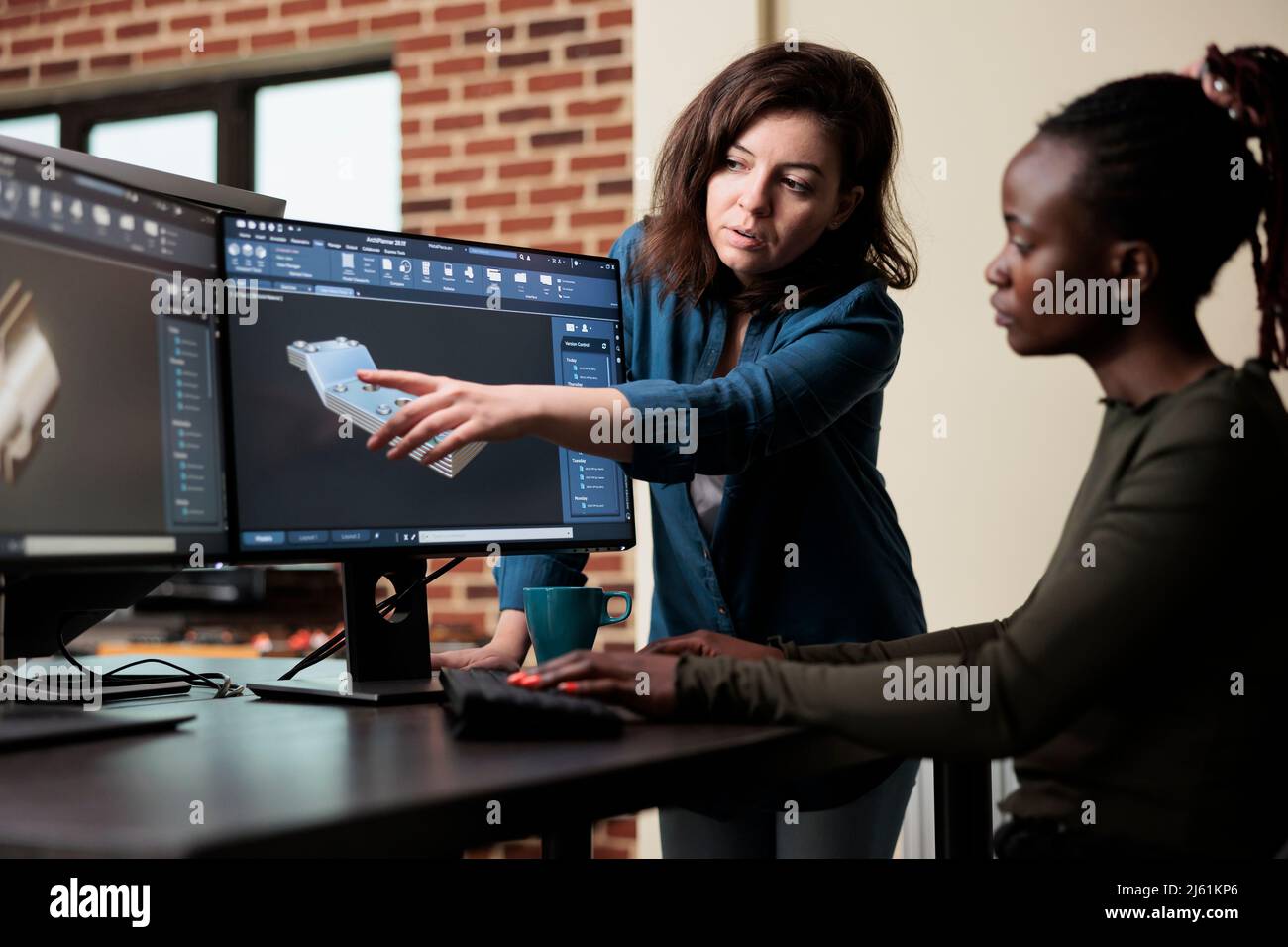 Le chef d'équipe du service de production indique un problème de géométrie du maillage et fournit une solution à un collègue. 3D artiste numérique collaborant avec un collègue afin de résoudre des difficultés techniques. Banque D'Images