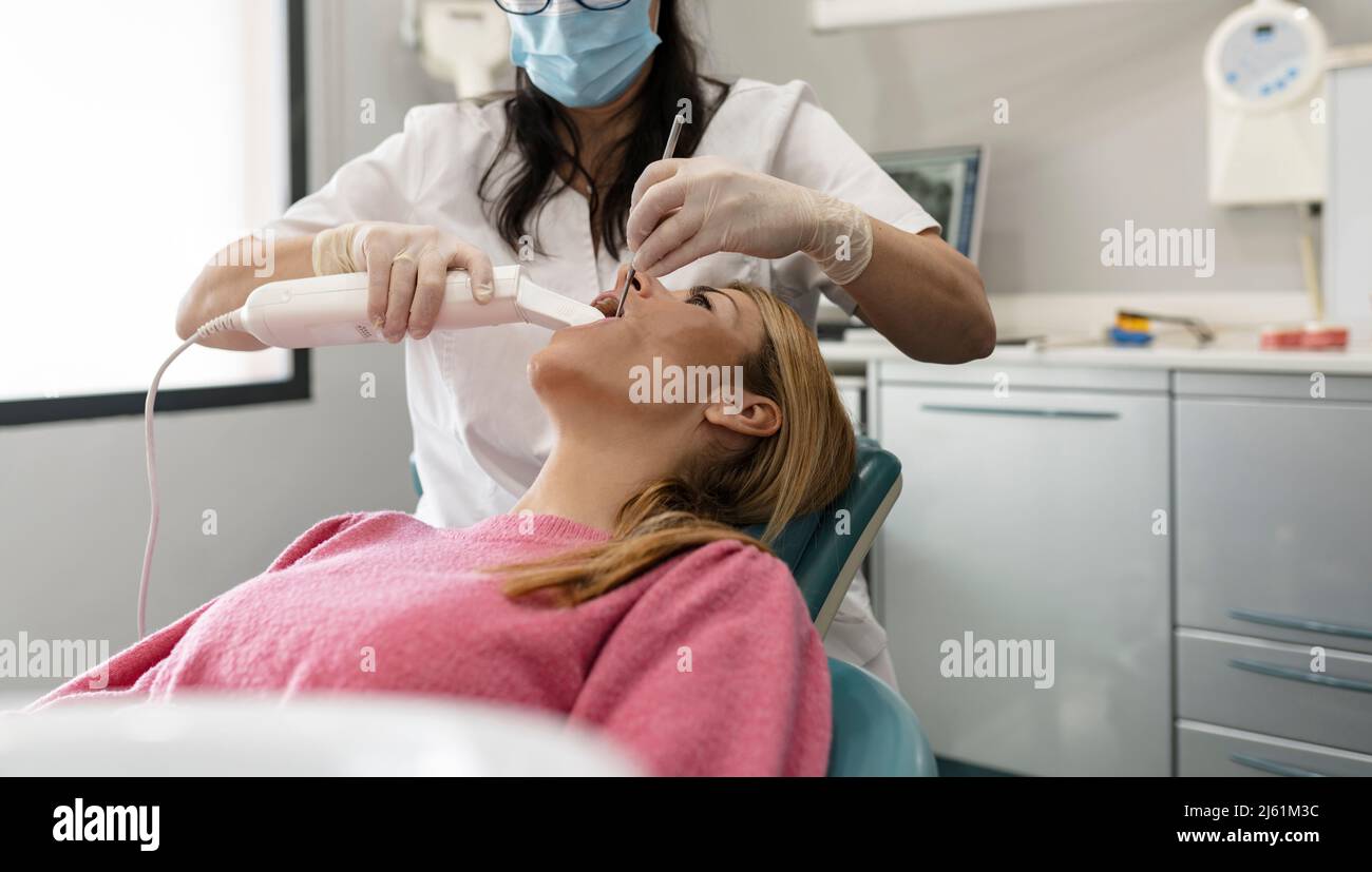 Dentiste examinant les dents avec de l'équipement dentaire à la clinique médicale Banque D'Images