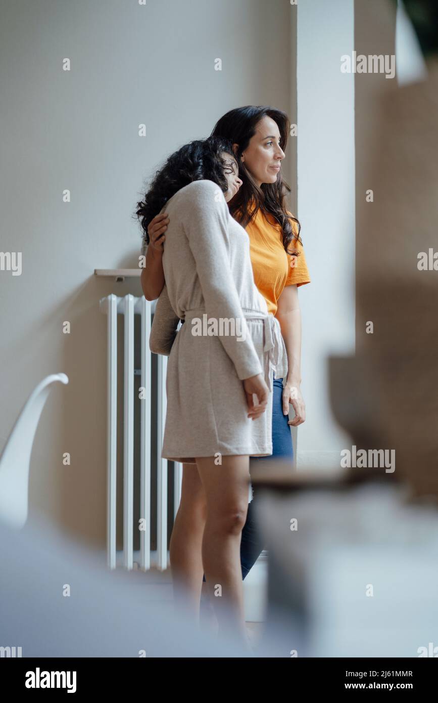 Une adolescente se repose la tête sur l'épaule de sa mère à la maison Banque D'Images