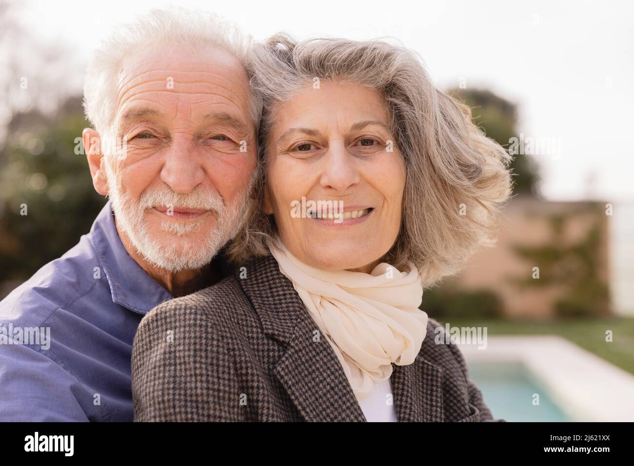 Couple senior souriant par beau temps Banque D'Images