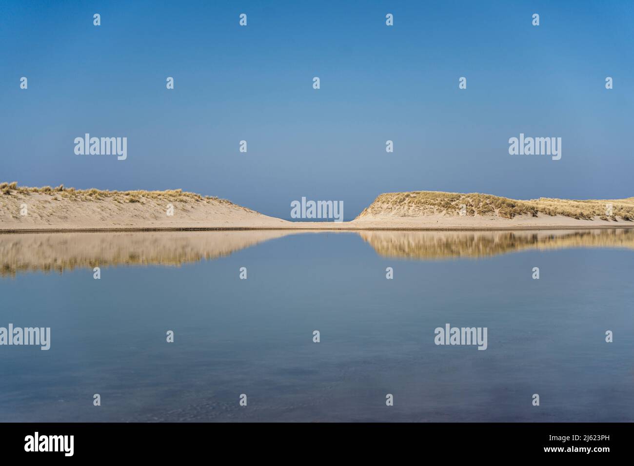 Lagune avec dunes de sable sous ciel clair Banque D'Images