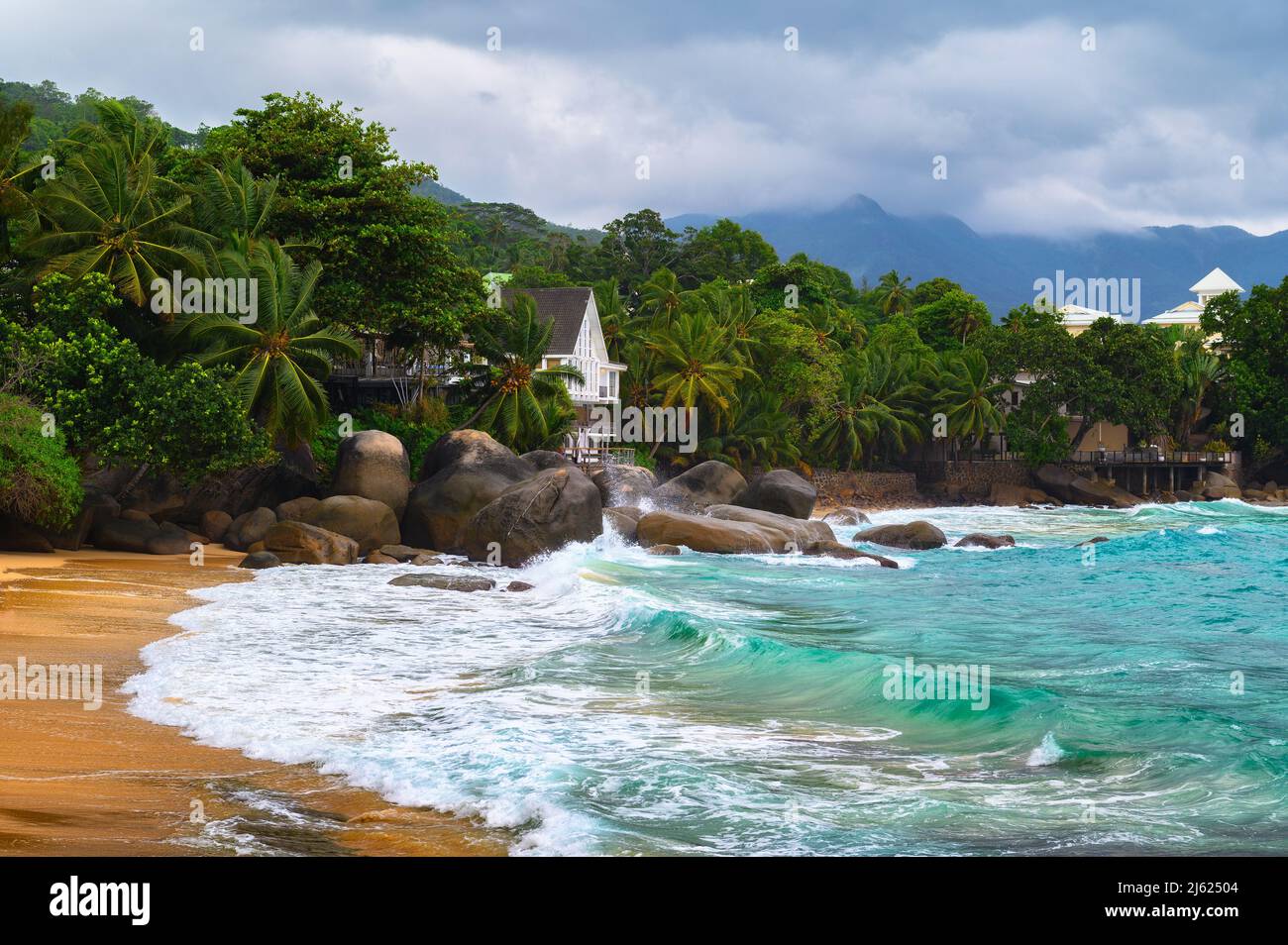 Plage de Glacis sur l'île de Mahé, aux Seychelles, avec de fortes vagues et de gros nuages Banque D'Images