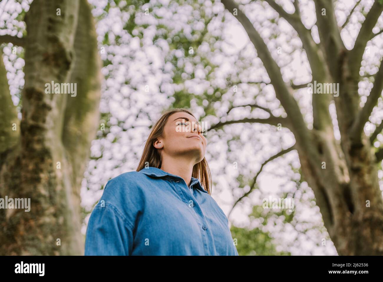 Jeune femme inhalant de l'air frais dans la nature Banque D'Images