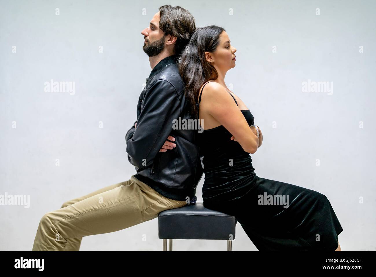 Couple frustré assis dos à dos avec les bras croisés Banque D'Images