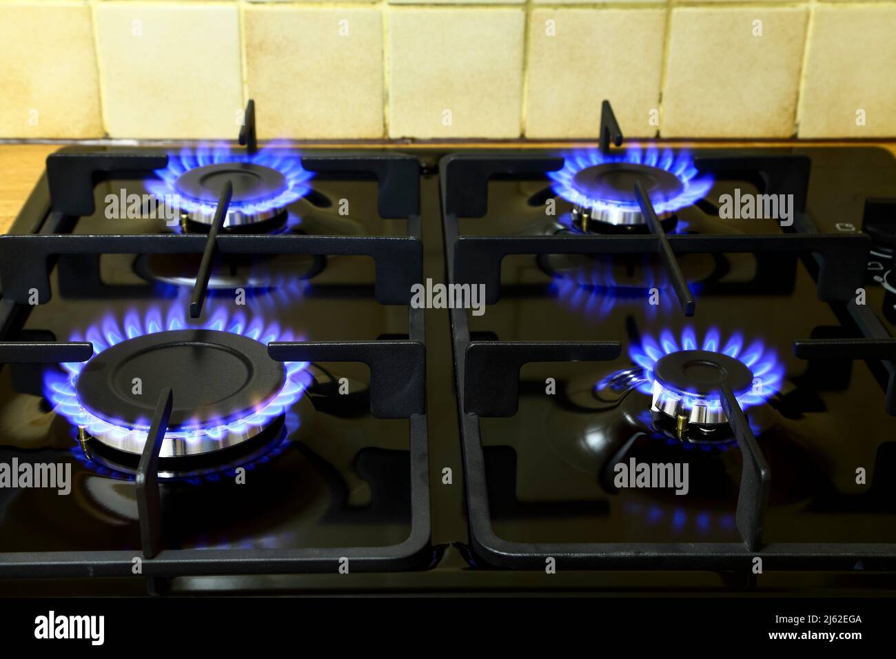 Quatre brûleurs allumés sur une table de cuisson à gaz Banque D'Images
