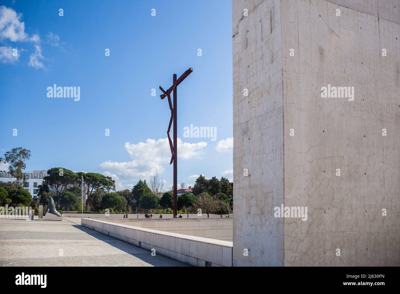 Croix moderne, appelée la croix haute de Robert Schad à Fatima Portugal en arrière-plan une statue du Pape Johannes Paul II, à genoux Banque D'Images