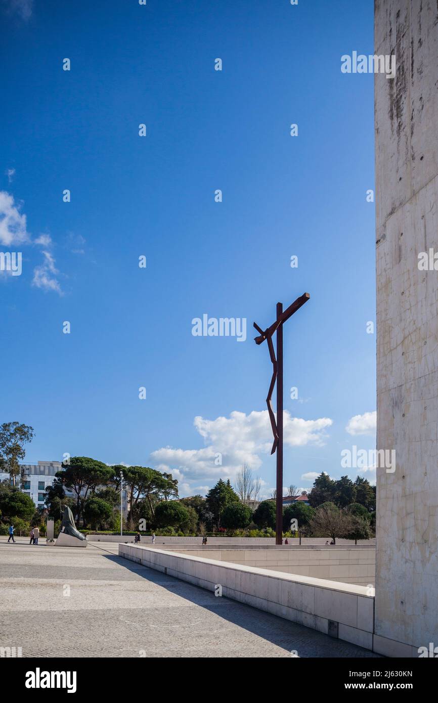 Croix moderne, appelée la croix haute de Robert Schad à Fatima Portugal en arrière-plan une statue du Pape Johannes Paul II, à genoux Banque D'Images