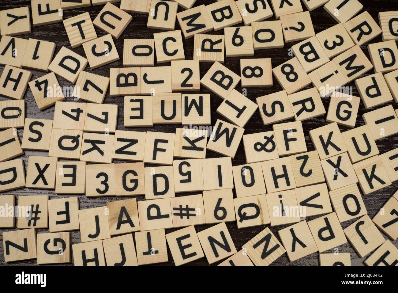 Carreaux en bois avec lettres et caractères latins sur une table (fond marron) Banque D'Images