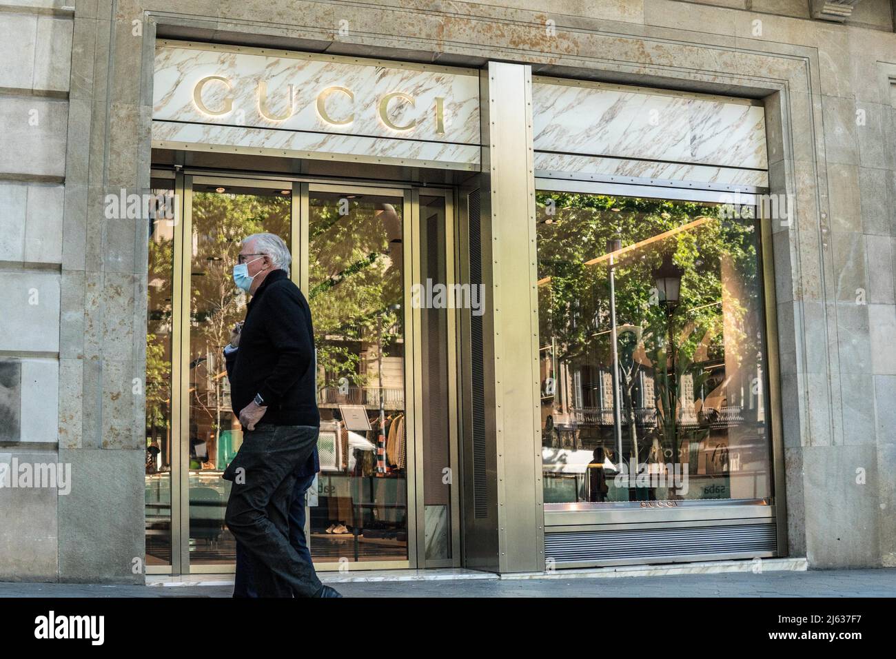 Un piéton passe devant le magasin de luxe italien Gucci à Barcelone. Banque D'Images