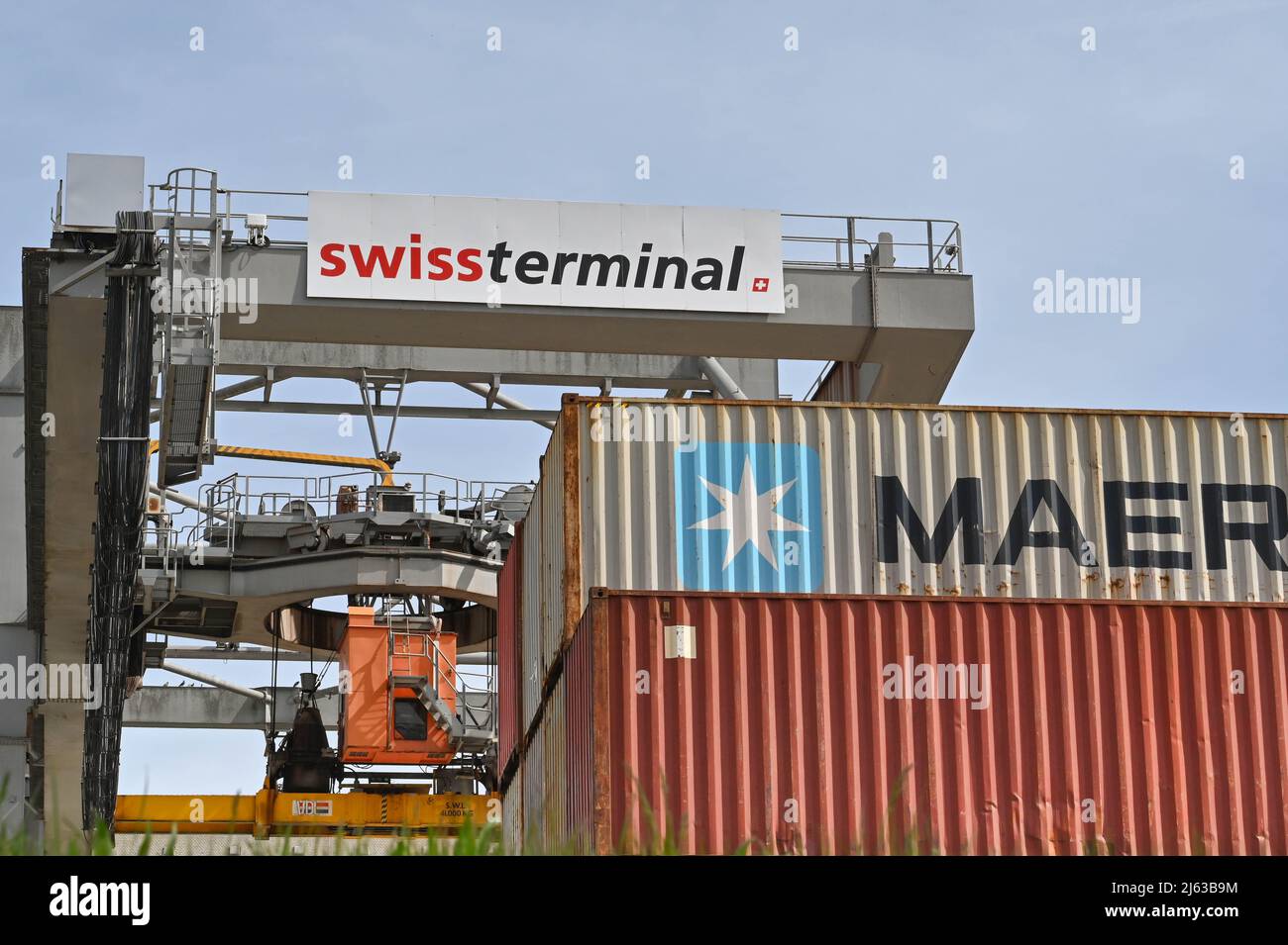 Bâle, Suisse - avril 2022 : grue lourde dans le terminal à conteneurs de la ville soulevant un conteneur d'expédition Banque D'Images