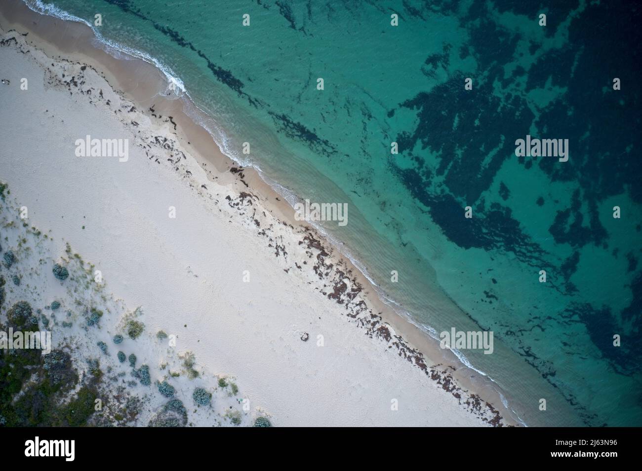 Champ de vision de drone des empreintes de pas dans le sable et l'eau de la plage au-dessus de l'Australie occidentale. Banque D'Images