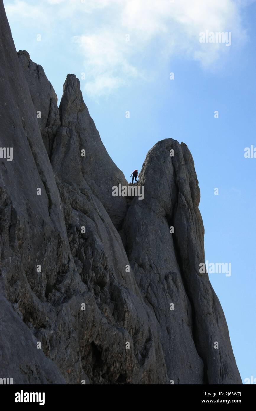 Grimpeur de montagne qui escalade une route escarpée dans les Alpes Banque D'Images