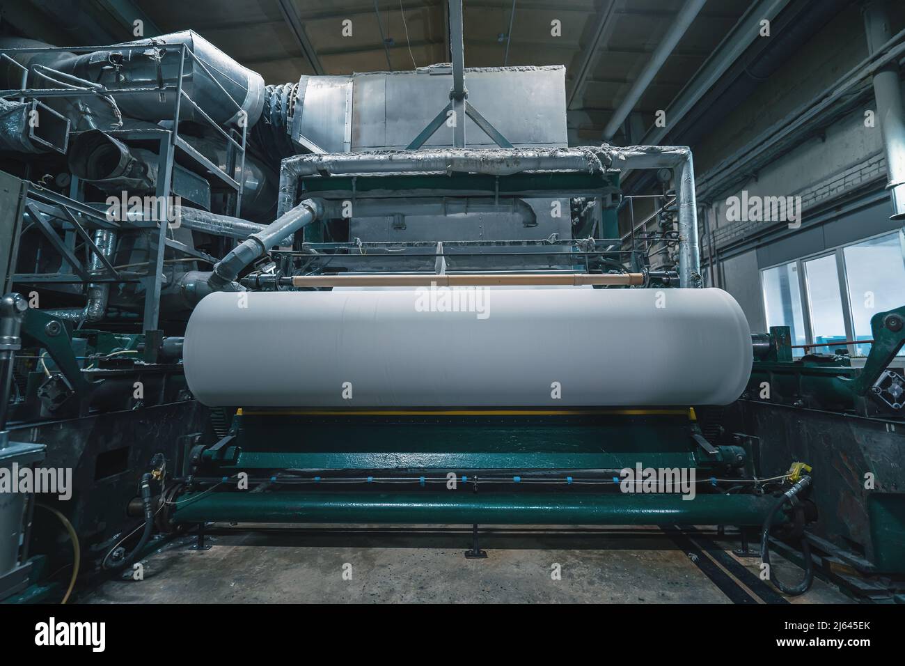 Machine de production avec rouleaux de papier neuf dans l'usine de recyclage de papier de rebut. Banque D'Images