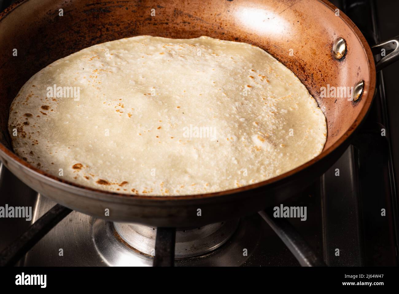 Cuisson de Tandoori Roti dans une poêle à frire, un pain plat typique et populaire en Asie occidentale, centrale et du Sud. Banque D'Images